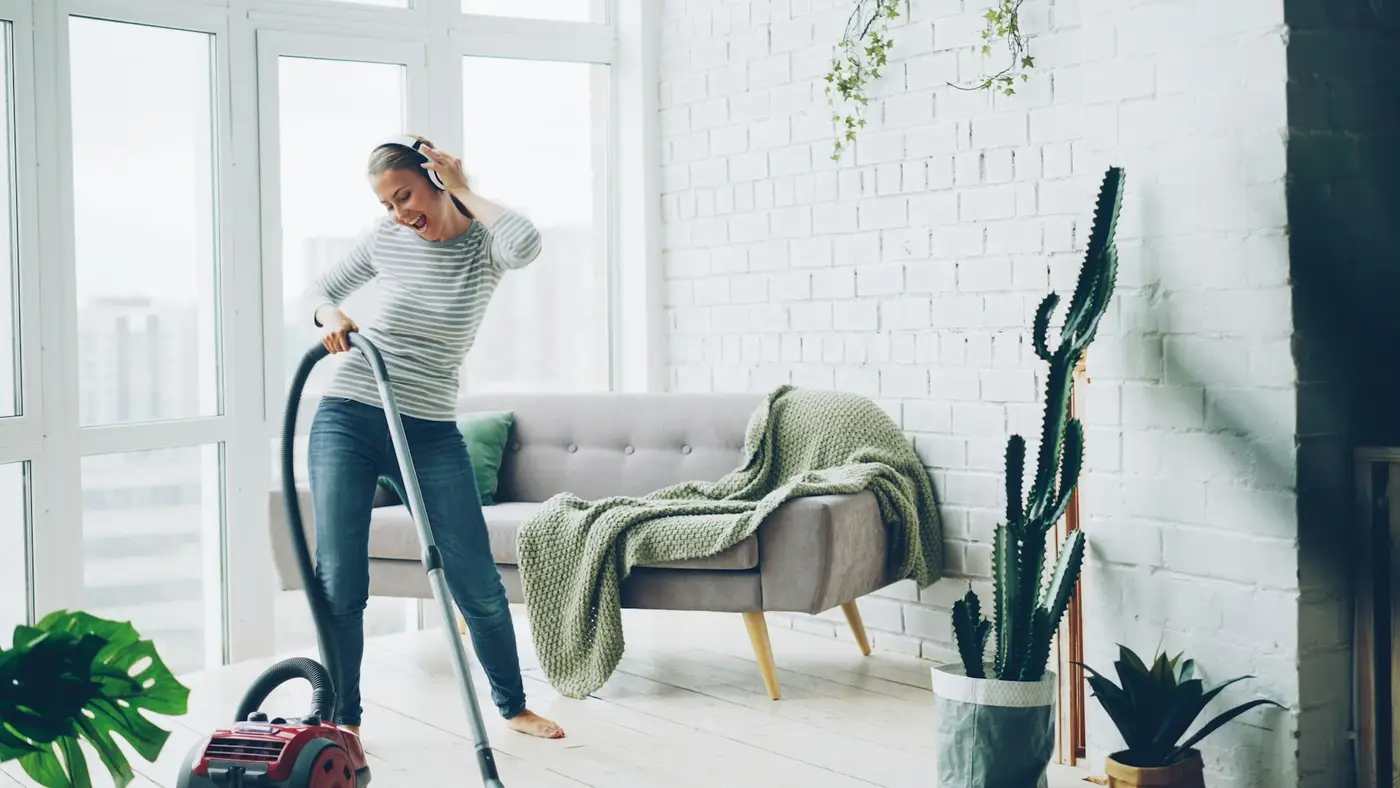 A cleaner vacuuming a bright, modern living room